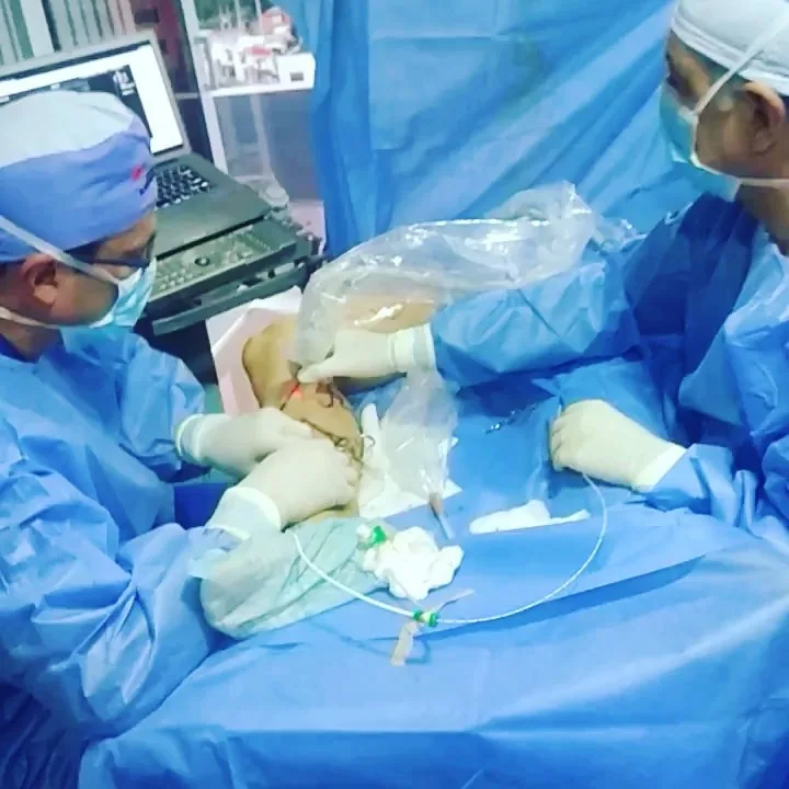 Equipo médico realizando una ablación endovenosa guiada por ecografía, con la luz de la fibra visible bajo la piel